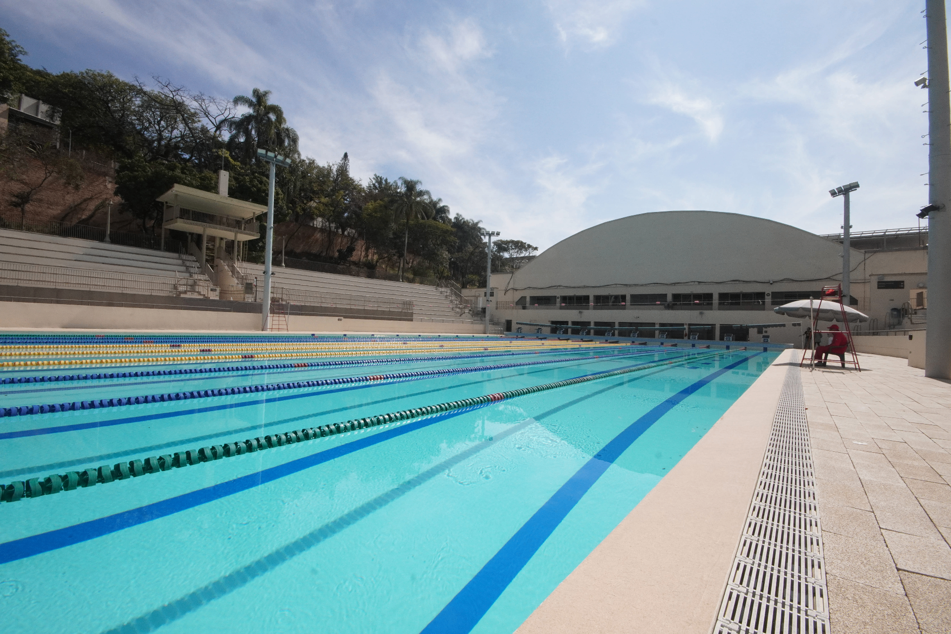 Piscina Mercado Livre em ângulo lateral com o ginásio ao fundo